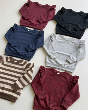 Angled view of the six ruffled crewnecks