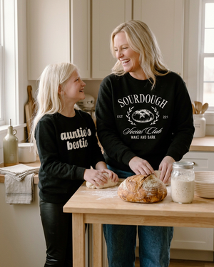 Auntie and niece baking sourdough in a warm kitchen