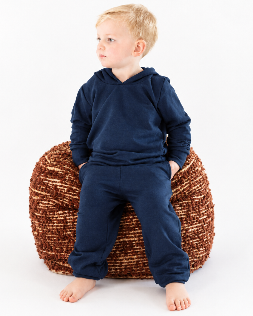 Boy in a navy hoodie and sweatpants with extra background space for cropping