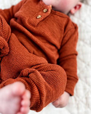 Close-up of baby’s romper recoloured to rust brown