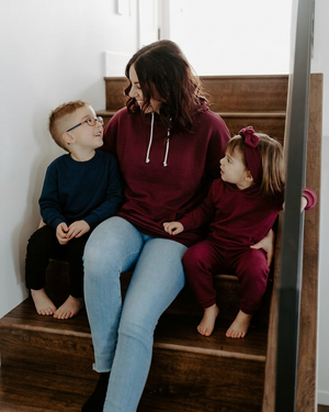Family on the stairs with Mom and daughter in burgundy and the boy in a plain navy sweater