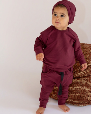Girl wearing a matching burgundy outfit and beanie
