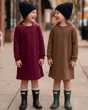 Girls in burgundy and brown dresses with black and dark green Hunter-style rubber boots