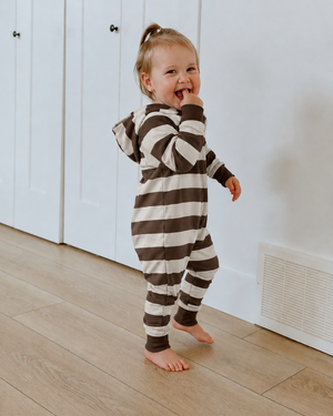 Little girl wearing a brown-and-cream striped hooded romper