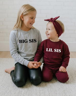 Sisters holding hands in BIG SIS and LIL SIS shirts
