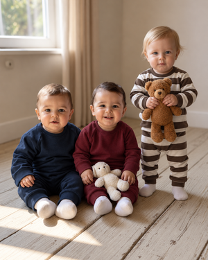 Three children wearing burgundy, navy, and brown-striped outfits