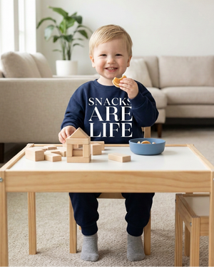Toddler with a larger SNACKS ARE LIFE print