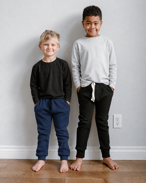 Two boys in long-sleeved tees, with navy pants on the younger boy